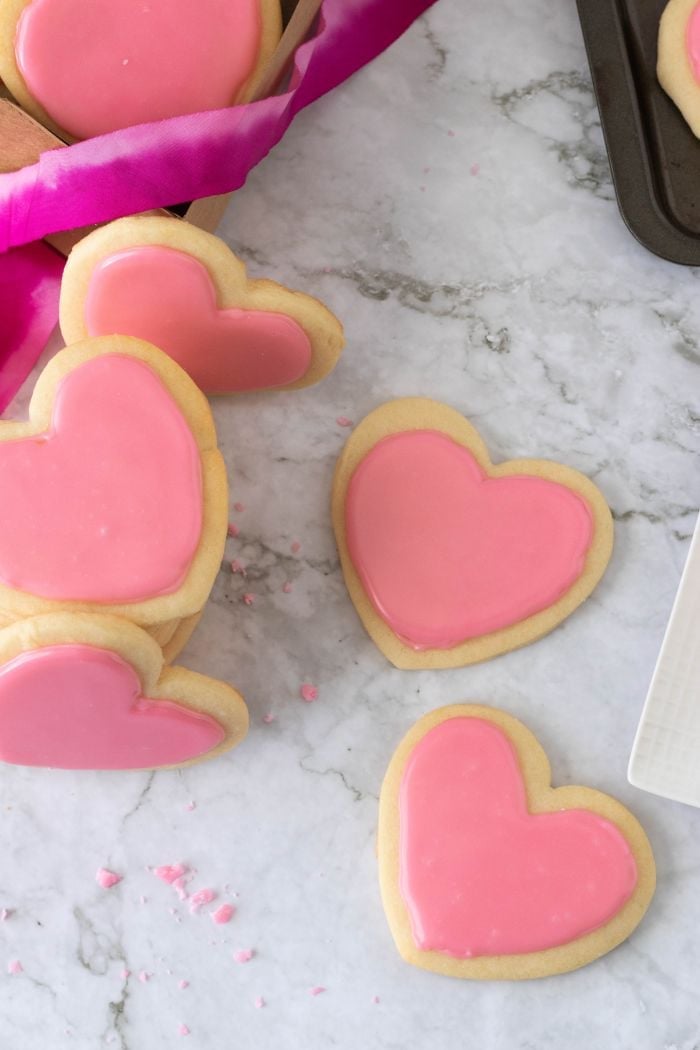 top down view of many heart shaped valentines day cookies, hearts with pink frosting